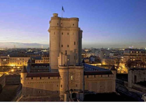 un bâtiment avec un drapeau en haut dans l'établissement Jolie Studette équipée sur jardin, st mandé bois, à Saint-Mandé