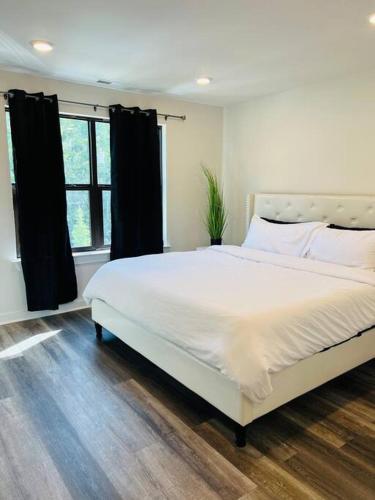 a bedroom with a large white bed and a window at Vacation Home in CLT King and 3Q in Charlotte