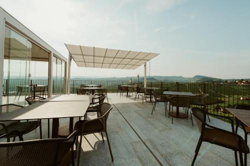 an outdoor patio with tables and chairs and windows at Palas Cerequio in La Morra