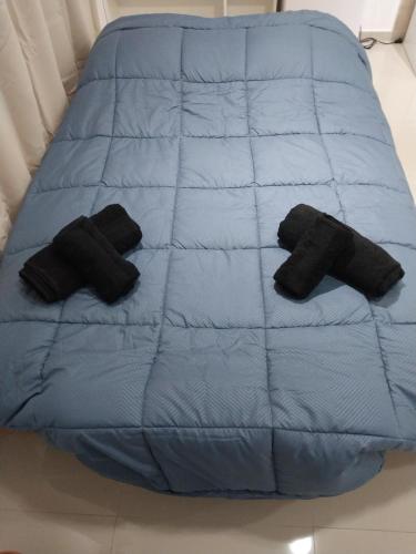 a blue bed with two black pillows on it at Alojamiento ByB in Plottier