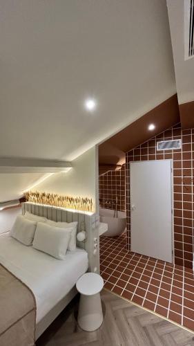 a bedroom with a bed and a bathroom with a tub at Hotel M Soleil - Montpellier Centre Saint Roch in Montpellier