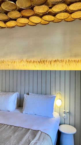 a bed with two pillows and a table in a room at Hotel M Soleil - Montpellier Centre Saint Roch in Montpellier