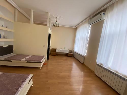 an empty room with two beds and a window at Beaming_House in Sheki