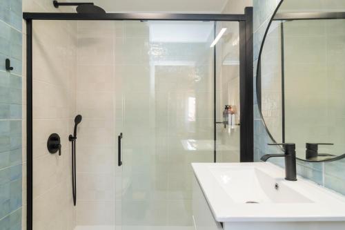 a bathroom with a shower and a sink and a mirror at Riverfront studio in Lisbon