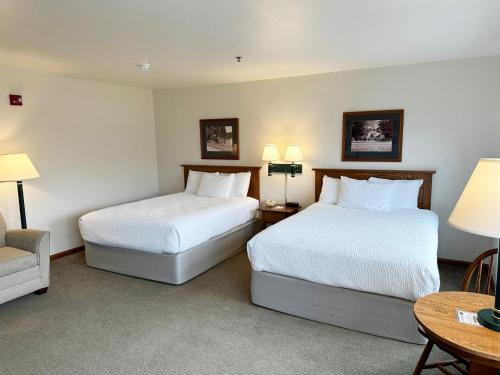a hotel room with two beds and a table at Farmstead Inn and Conference Center in Shipshewana