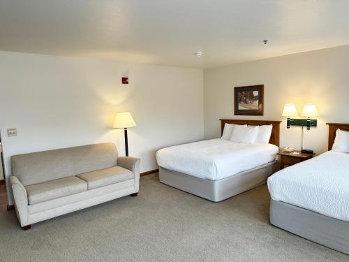 a hotel room with two beds and a couch at Farmstead Inn and Conference Center in Shipshewana