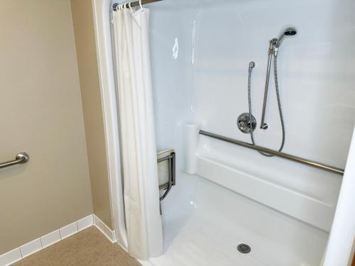 a bathroom with a shower with a shower curtain at Farmstead Inn and Conference Center in Shipshewana