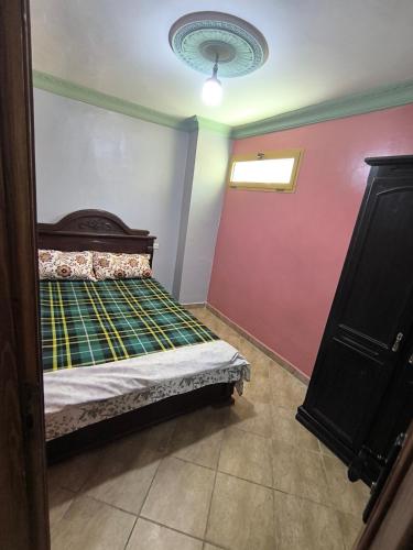 a bedroom with a bed and a red wall at Appartement a Martil in Martil