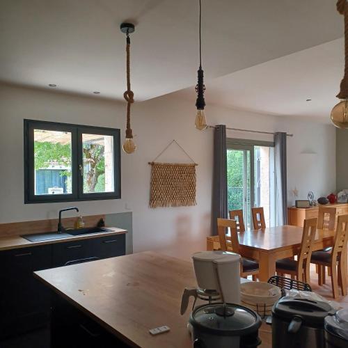 une cuisine et une salle à manger avec une table et des chaises dans l'établissement Domaine Anges et Oiseaux 2 à 10 personnes, à Saint Paul de Loubressac