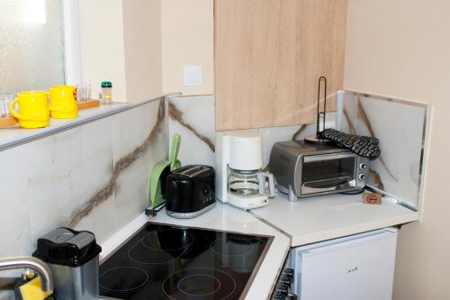 a kitchen with a stove and a microwave at Допълнителна къща за гости Ози 2 in Ovchartsi