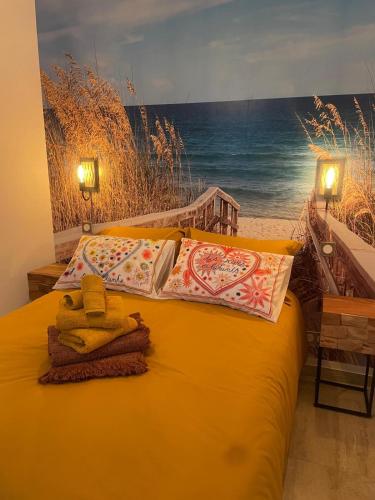 - un lit jaune avec des oreillers et une peinture sur la plage dans l'établissement Chic, Luxury & Spacious F4 in Old Town AC, à Béziers