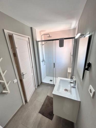 a bathroom with a sink and a mirror and a shower at SunAndBed ATICO FARO in Salou