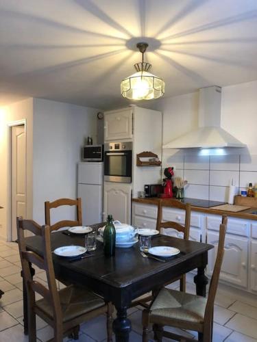 une cuisine avec une table avec des chaises et une salle à manger dans l'établissement gite Sivry la perche cœur de Logis, à Sivry-la-Perche