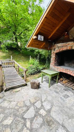 a picnic table and a bench next to a brick oven at Kuća za odmor Bajka in Jastrebarsko