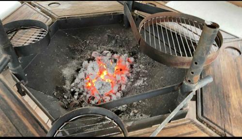a grill with a fire inside of it at Orchard Retreat - Rural Cabin - Private Hot Tub! in Gloucester