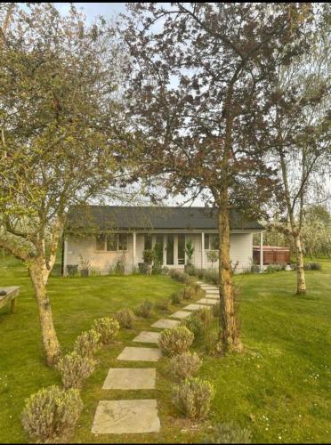 a house with a walkway in front of a yard at Orchard Retreat - Rural Cabin - Private Hot Tub! in Gloucester