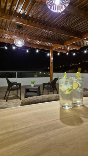 a table with two glasses of drinks on a table at Apartamento duplex a 1 cuadra de Playa Naplo in Pucusana