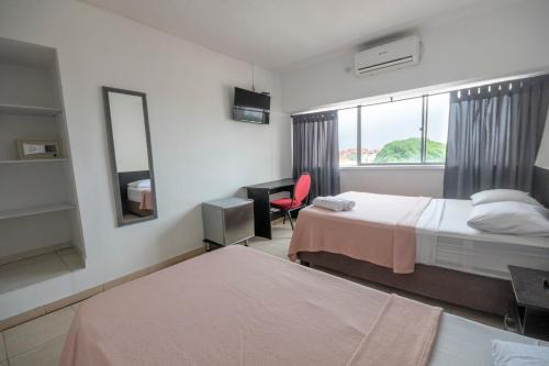 a hotel room with two beds and a window at Hotel Stil Cartagena in Cartagena de Indias