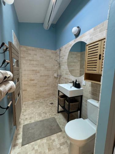 a bathroom with a toilet and a sink and a mirror at La bohème in Lourmarin