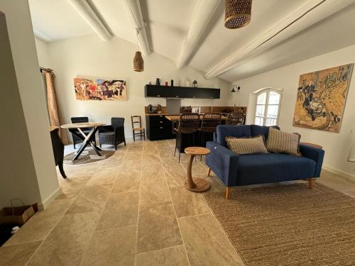 un salon avec un canapé bleu et une table dans l'établissement La bohème, à Lourmarin