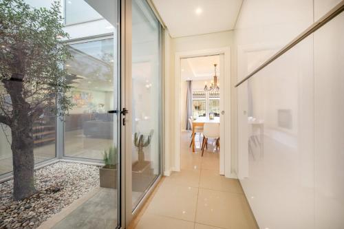 un corridoio con porta a vetri che conduce a una sala da pranzo di GuestReady - Sunshine oasis with pool ad Azeitao