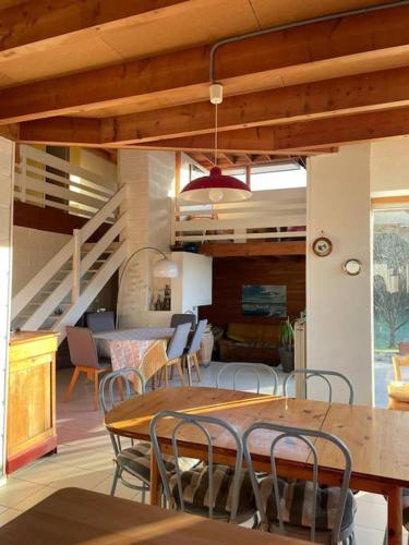 une salle à manger avec une table et des chaises et un escalier dans l'établissement FileOVent, à Combrit