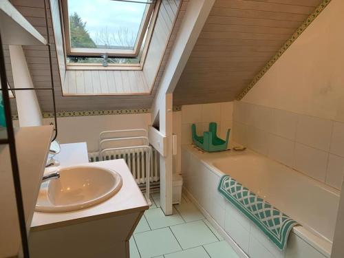 La salle de bains est pourvue d'un lavabo, d'une baignoire et d'une fenêtre. dans l'établissement FileOVent, à Combrit
