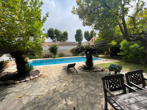 une arrière-cour avec une piscine et deux bancs dans l'établissement Mas Catalan avec piscine 12 à 15 personnes, à Argelès-sur-Mer