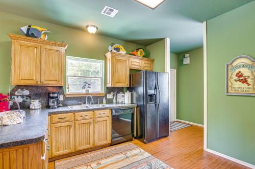 a kitchen with wooden cabinets and a stainless steel refrigerator at half Mi to Lake Texoma Home with Fire Pit and Grill! in Kingston