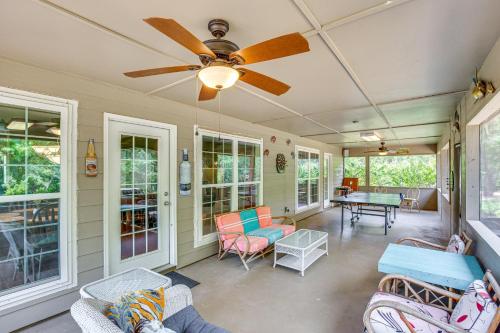 a screened in porch with a ceiling fan and chairs at half Mi to Lake Texoma Home with Fire Pit and Grill! in Kingston