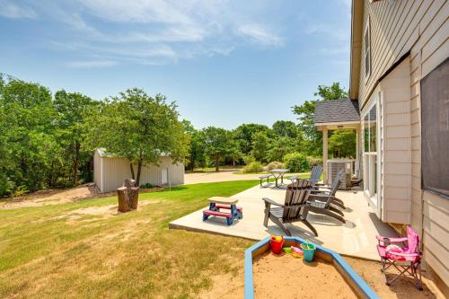 a patio with chairs and a sandbox next to a house at half Mi to Lake Texoma Home with Fire Pit and Grill! in Kingston