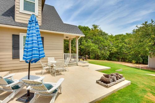 a patio with chairs and an umbrella and a grill at half Mi to Lake Texoma Home with Fire Pit and Grill! in Kingston