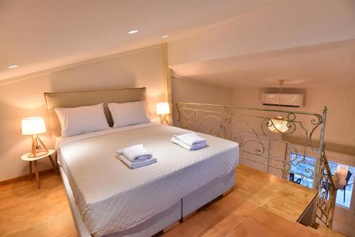 a bedroom with a bed with two towels on it at Thea Suite & Loft in Kavala