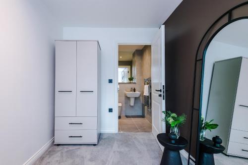 a bathroom with a white closet and a sink at Stylish Leeds City Centre Flat - Free Parking in Leeds