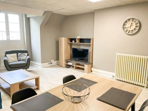 ein Wohnzimmer mit Tisch und Kamin in der Unterkunft Appartement 2 moderne - centre in Alençon