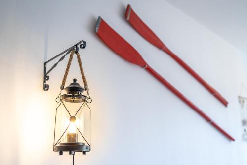a lantern hanging on a wall with some sticks at MOOKI Beach Apartment in Bodensdorf