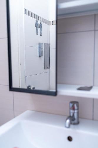 a mirror above a bathroom sink with a door at MOOKI Beach Apartment in Bodensdorf