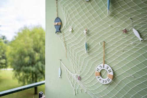 a net with a donut hanging on a wall at MOOKI Beach Apartment in Bodensdorf