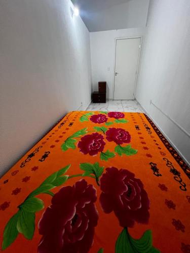 a room with an orange bed with flowers on it at Casa Ana Brutomesso 1 in Londrina