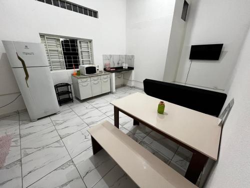 a living room with a table and a refrigerator at Casa Ana Brutomesso 1 in Londrina