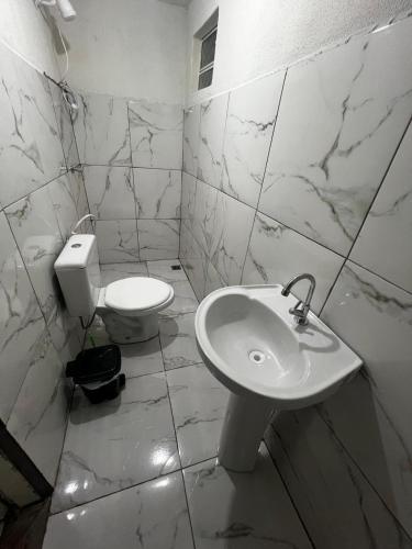 a white bathroom with a toilet and a sink at Casa Ana Brutomesso 1 in Londrina
