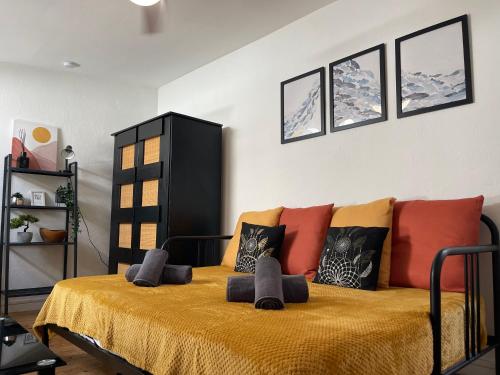 une chambre avec un lit avec des oreillers colorés dessus dans l'établissement Asian Touch - A deux sous les toits, à Nîmes