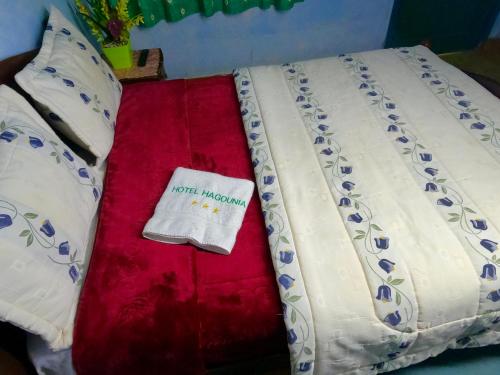 a bed with a red and white comforter at Hagounia hotel in Tan-Tan