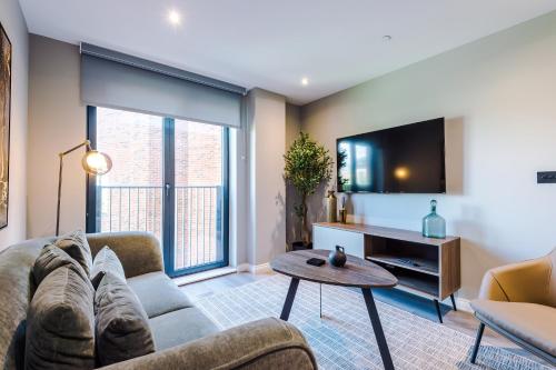 a living room with a couch and a tv at Premium 3 Bed Apartment City Centre - Free Parking in Leeds