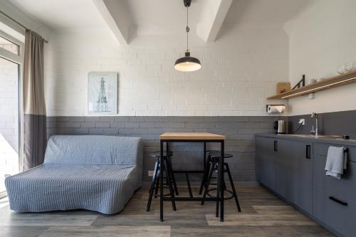a kitchen with a table and a stool in a room at Smiltynės Jachtklubas in Klaipėda