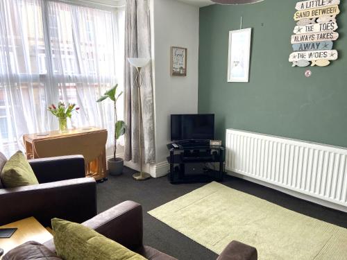 a living room with a couch and a tv at Marina Holiday Apartments in Bridlington