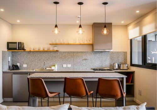 a kitchen with a counter with chairs around it at Gluck Patagonia Aparts in Villa La Angostura