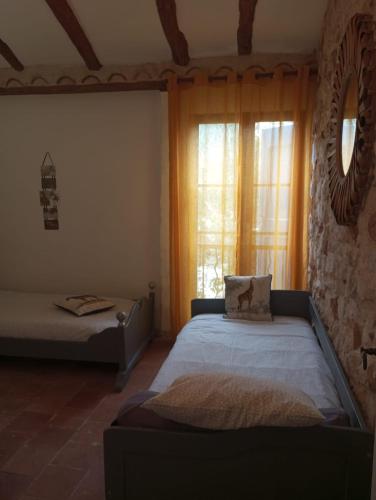 une chambre avec un lit et une fenêtre dans une pièce dans l'établissement Magnanerie Le Mas d'Elise, à Boisset-et-Gaujac