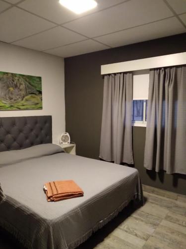 a bedroom with a bed with a brown purse on it at Cabañas Gadiel in San José de las Salinas