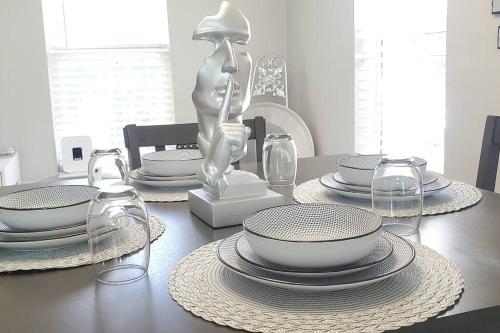 a table with plates and bowls and a statue on it at Welcome to Tranquility House in Tampa